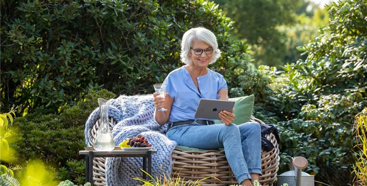 Gartenfreizeit - Frau mit Tablet im Garten